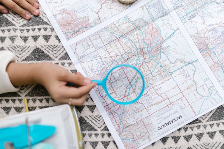 A top view of a hand holding a magnifying glass over a map, emphasizing Local SEO
